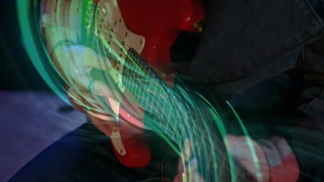 Guitarist hands starting on fretboard and picking, green trails growing and swirling to show sound