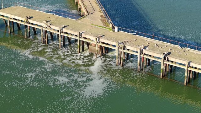 Aerial view of a wastewater treatment discharge point on a jetty into the River Orwell estuary in Ipswich UK