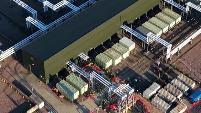 Close up aerial view of Bramford electrical substation near Ipswich, UK, showing high voltage transformers, busbars, and power line infrastructure.