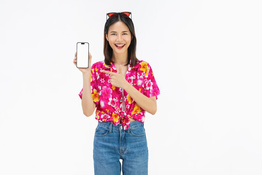 Portrait of young Asian woman in summer wearing floral shirt holding smartphone mockup of blank screen and smiling on white background