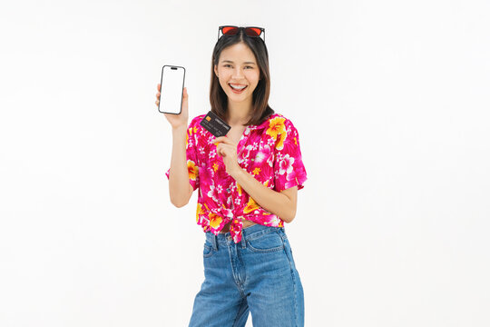 Portrait of young Asian woman in summer wearing floral shirt holding smartphone mockup of blank screen and smiling on white background.