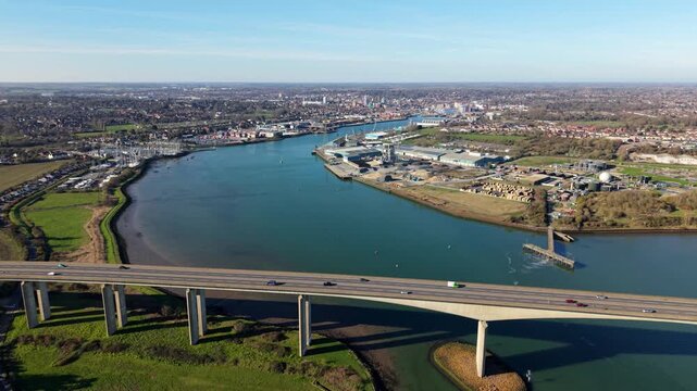 Aerial view of the massive Orwell Bridge spanning the River Orwell estuary near Ipswich, traffic crossing a concrete road bridge over blue water on a sunny day in Suffolk, UK.