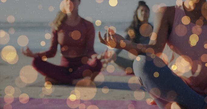 Right woman in mudra on beach, camera shifting focus while bokeh overlay highlighting meditation