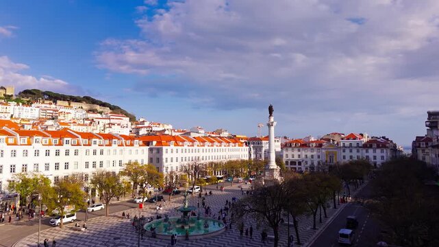 Establishing shot of Rossio Square with Sao Jorge Castle and Lisbon rooftops at golden hour