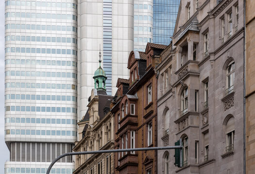 Modern glass skyscrapers contrasting with historic traditional buildings in urban city center, architectural diversity