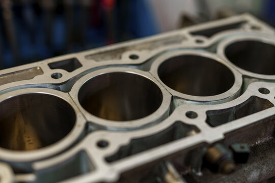 Close-up view of an aluminum engine block with empty cylinders.