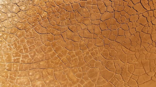 Aerial view of cracked red earth and dry mud patterns in the mining landscape of Minas de Riotinto, Andalusia, Spain.