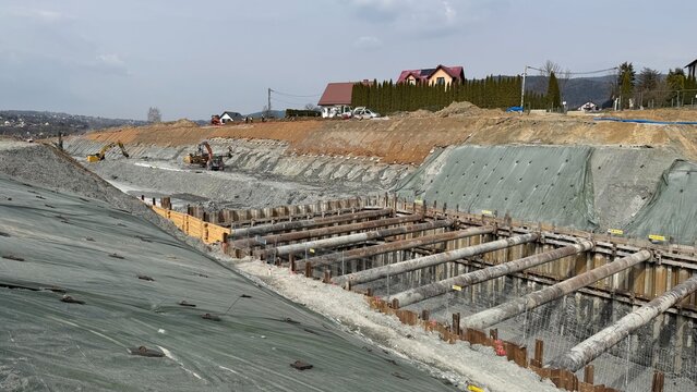 Construction of railway line LK104 with advanced ground stabilization and engineering structures. Geotechnical works including pile walls, soil reinforcement, ground nails, and slope protection system