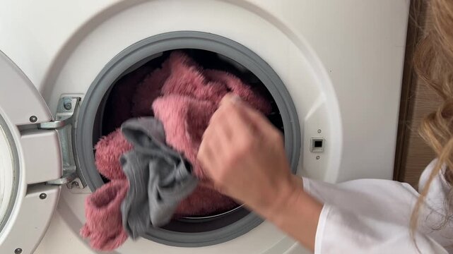 Mujer metiendo la ropa sucia en la lavadora
