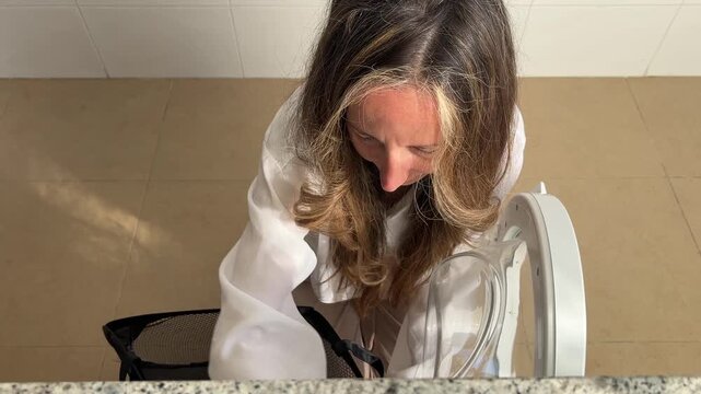 Mujer sacando la ropa de la lavadora en plano cenital