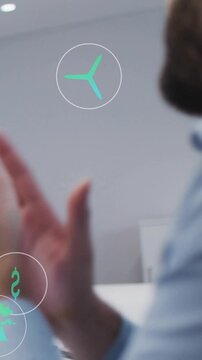 Vertical video: Office man reaching phone, applauding presentation while green AR icons overlaying