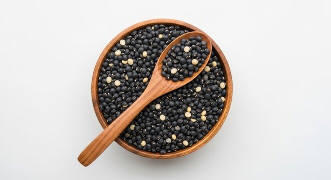 Wooden bowl and spoon with black urad dal on white background