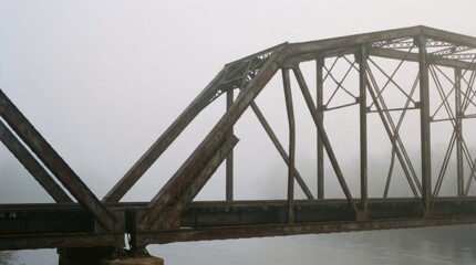 Fototapeta premium Foggy Steel Bridge Over Water with Deteriorating Structure