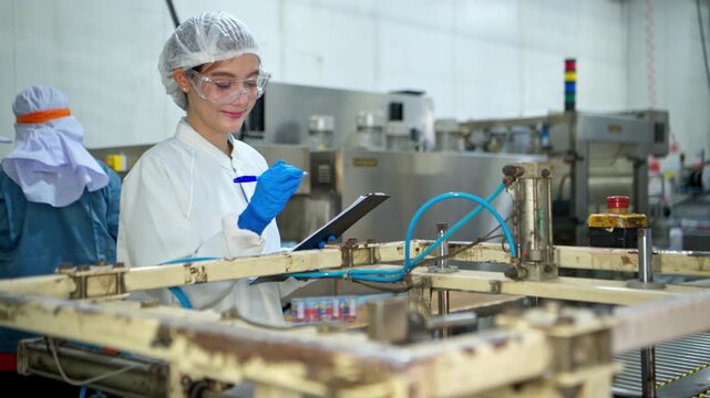 The production supervisor is inspecting and controlling the operation of packaging line of the canned fish processing plant