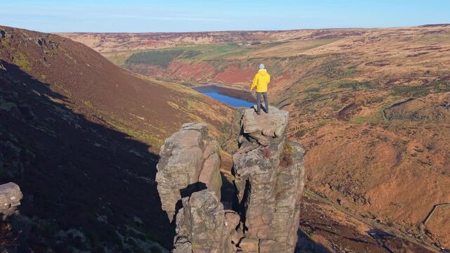 Drone POV of Man demonstrating view from the highly exposed rock. The Trinnacle is a remote and highly exposed rock formation in the Peak District near the town of Oldham at around 900ft in altitude.