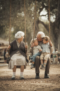 Retirees playing with their grandchild while sharing a fun and loving swing ride at a rural playground