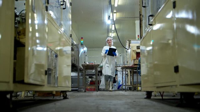 The production supervisor is inspecting and controlling the operation of packaging line of the canned fish processing plant