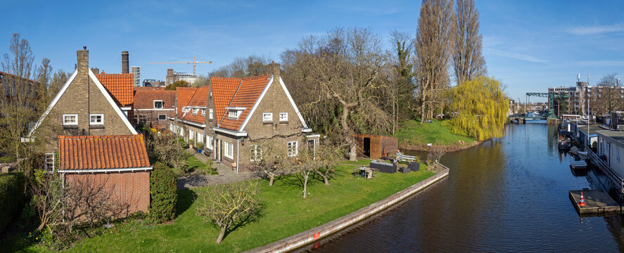 View on river Rhine in Leiden (Netherlands), the Singel drawbridge , and one of the famous courtyards, (hofje) to the left, on a sunny day in early spring . 