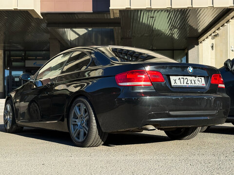 Black BMW 3 series V E 92 coupe in a parking lot. Motor car BMW M3 320d E92 2008 parked on street. Exterior of a German sport car BMW M3 E 92 coupe black color.