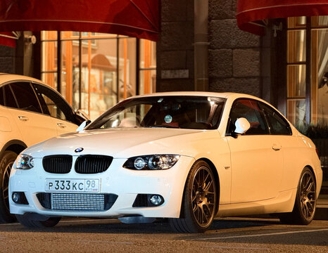 BMW 3 series V E 92 Coupe ALPINE WHITE in a parking lot. Motor car BMW M3 330  E92 parked on street. Exterior of a German sport car BMW M3 E 92 Coupe white color.