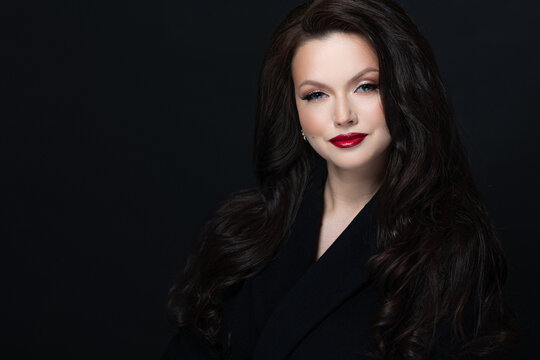 Dark studio portrait of brunette with red lipstick