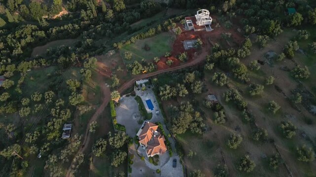 Aerial view of a property with a house, pool, and construction.