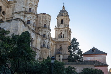 Fototapeta premium Church towers stand tall in Malaga Spain under clear sky during late afternoon