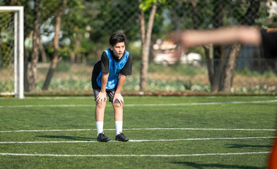 Fototapeta premium International school student resting during football training session on the field