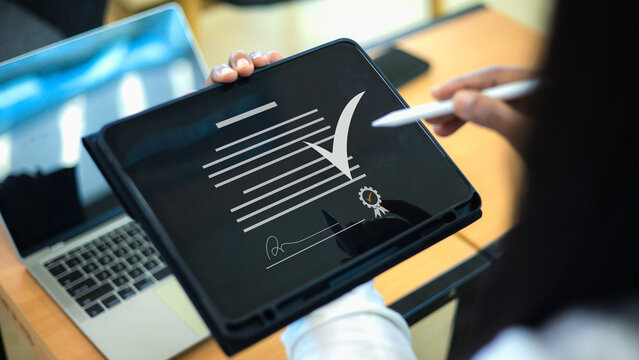 Digital signature on tablet computer.Electronic contract and agreement signing.Paperless office digital document solution.Online legal document verification concept.Use signing electronic form online.