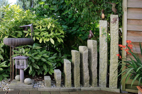 Gr&uuml;npflanzen mit Deko und Granitsteinen im Garten