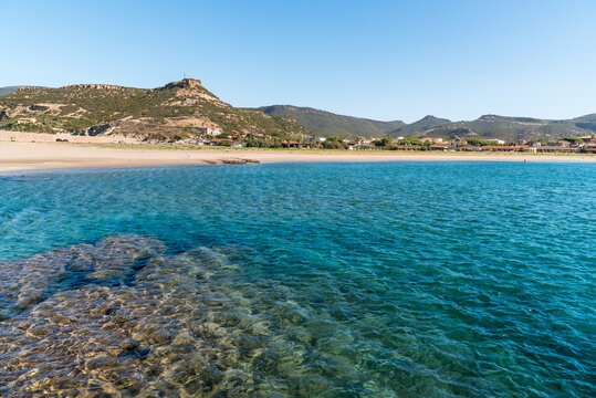 The coast of Bosa Marina, a charming seaside village located in Sardinia, Italy. Scenic Mediterranean coastline with sandy beach, colorful buildings, and clear blue sea.