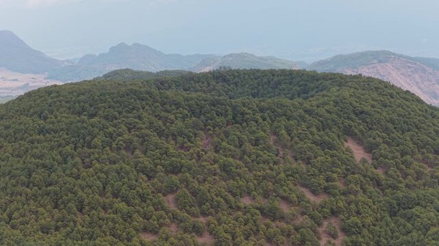 Aerial view of a lush green volcano covered with trees, a symphony of nature's artistry captured from above, Tengchong, Yunnan, China.