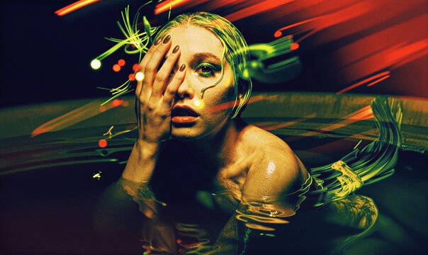 Neon Light Trails And Female Silhouette Submerged In Water