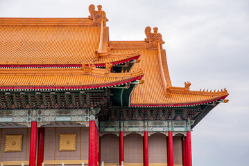 Golden roof tiles curve gracefully under overcast skies. Red pillars stand tall with ornate wooden beams. Traditional Chinese architecture highlights symmetry and grandeur. Ideal for cultural, travel © Gabriel