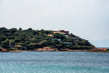 Fototapeta premium A view of the rocky shoreline on the Vouliagmeni coast on the Saronic Gulf in Greece.