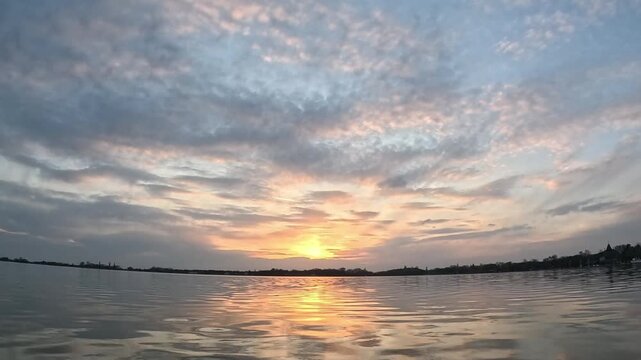 The sky and the lake, the sky in clouds, through them, illuminating them with bizarre purple colors, the sun sets very beautifully, the water reflects it and slowly ripples