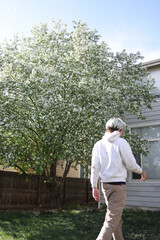 Obraz premium Adult man walking in backyard during spring bloom
