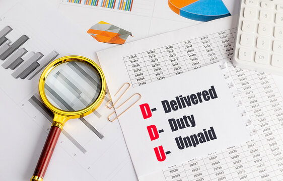 Paper with ddu delivered duty unpaid text with magnifier calculator and charts international trade shipping concept
