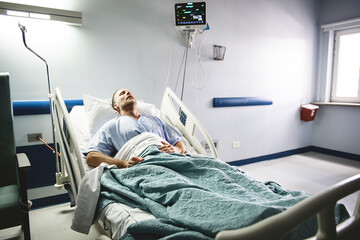 man in hospital bed suffering from cancer or other health problem