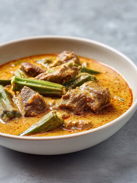 A rich and creamy West African peanut stew (Maafe) featuring tender beef chunks and whole okra pods in a savory spiced sauce.