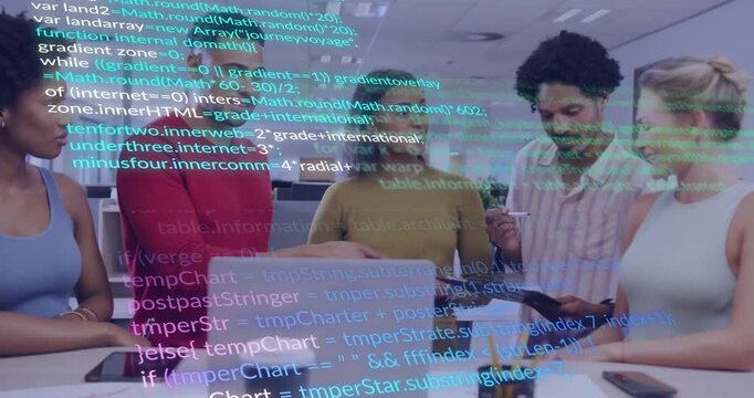 Software development team gathering around laptop and tablet in modern office, showing code overlay