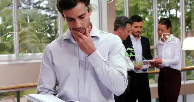 Man opening binder pages while team consulting on tablet and environmental hex icons forming