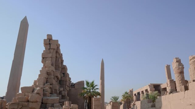 The ancient stone obelisk of Queen Hatshepsut standing tall within the historic ruins of the Karnak Temple complex in Luxor, Egypt.