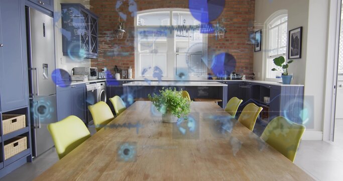 Anchoring wooden table holding potted plant in kitchen with chartreuse chairs and blue overlays