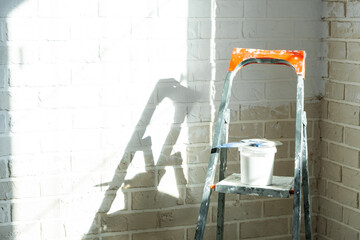 Interior wall painting works, stepladder and paint tools, home renovation, finishing, room decoration, professional wall finish process. © Ольга Симонова