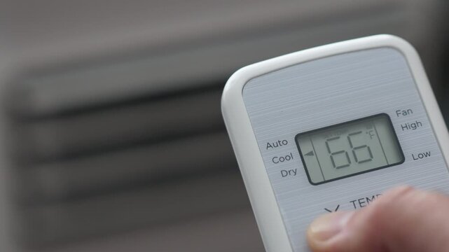 Turning Down Temperature on Thermostat in Summer in Hot Weather. Setting Digital Home Thermostat to Cool and Programming Air Conditioner. Adjusting Room Temperature to Energy Saving in Summer Heat.