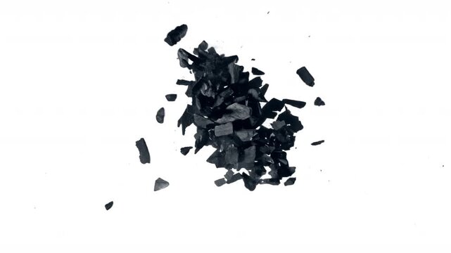 Super Slow Motion Flying and Colliding Charcoal Isolated On White Background at 1000 fps.