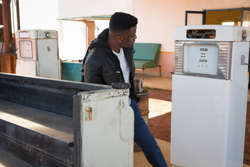 Vintage fuel pumps standing by metal counter, sunlight casting shadows across dusty service area © wavebreak3