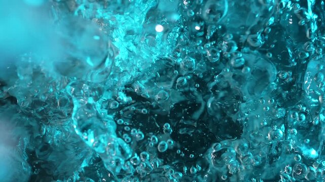 Top view of a ice cubes falling into water with oxygen bubbles, frost patterns, and soft light reflections. Concepts for beauty advertising, menu designs for bars and restaurants, cryotherapy.
