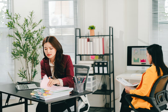 The female employees are working and searching for documents. The female accountant is preparing the company's annual taxes.